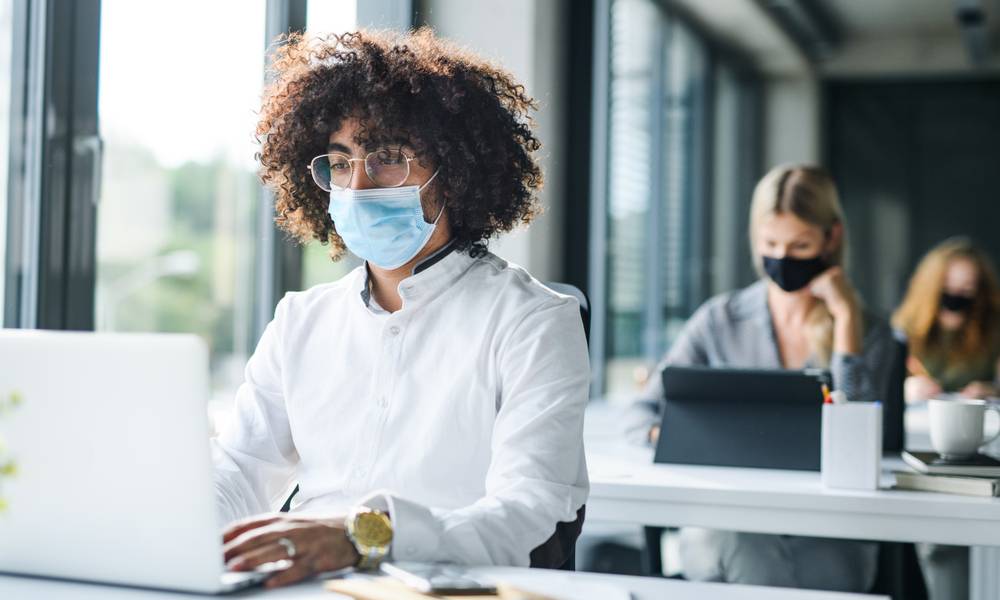 Colleagues wear masks while social distancing in an office (1).jpg