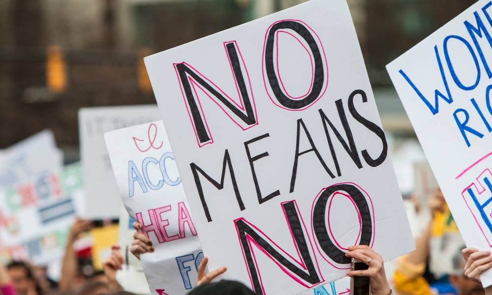 Person holds sign that reads no means no during protest.jpeg