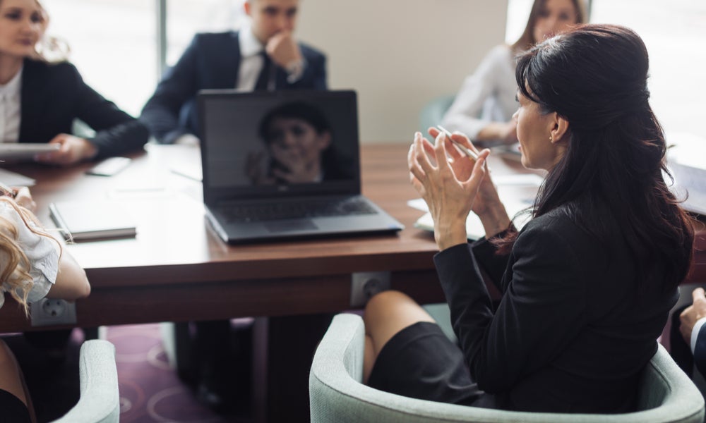 Business woman leads a meeting around a table.jpeg