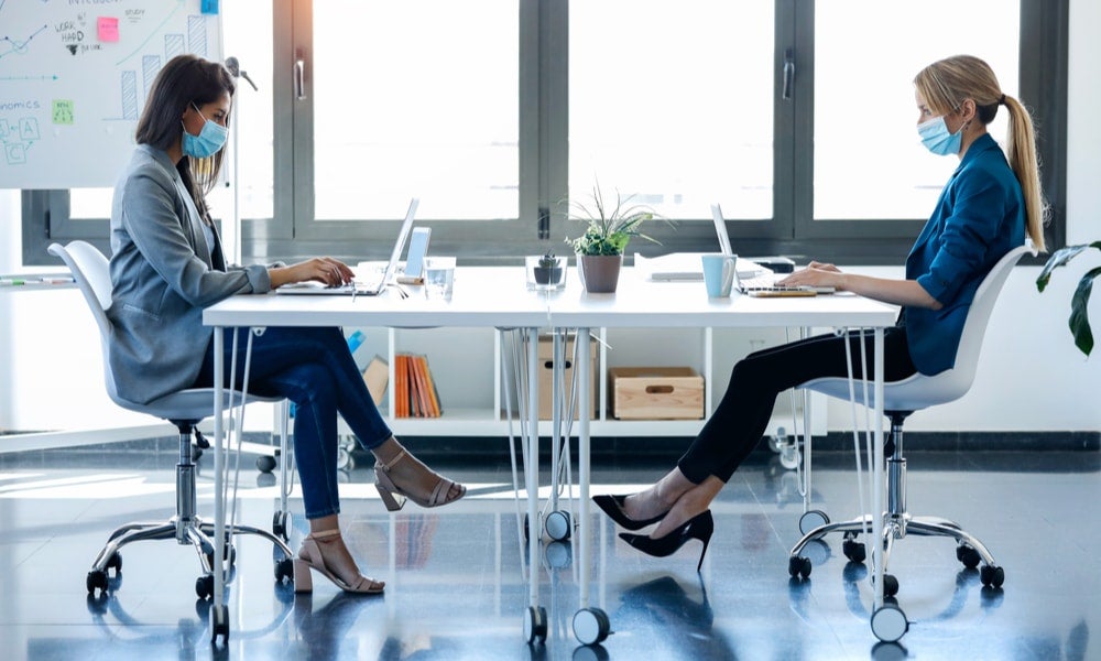 Colleagues in an office wear protective masks during coronavirus pandemic-min.jpg