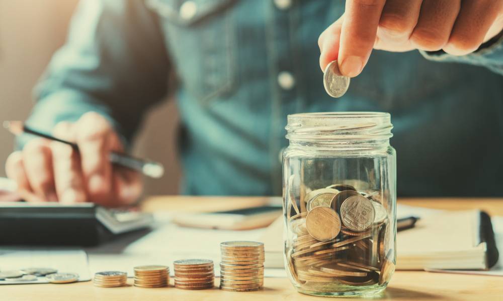 businessman holding coins putting in glass.jpg
