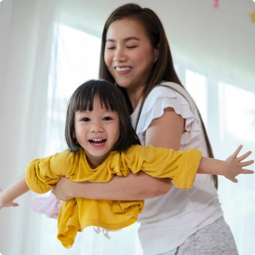 Mother carrying her child and smiling.