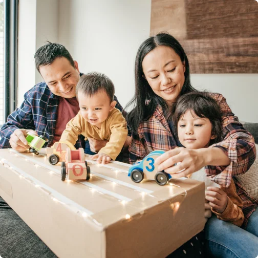 Family playing with toy cars together.