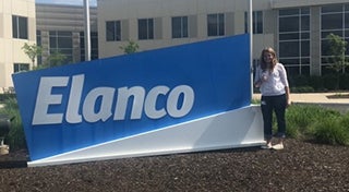 a woman stood next to an outside Elanco animal health sign