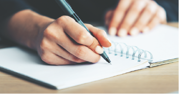 a person writing on in a notebook