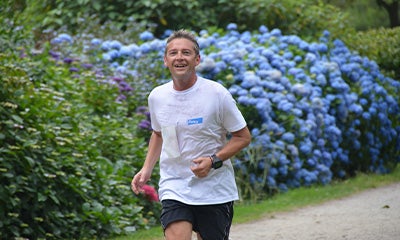 An Elanco employee running with a smile on their face