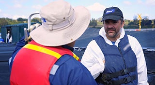 two men with life jackets and hats on looking at each other