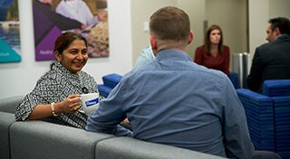 woman smiling at a male with his back turned to the camera sat in a waiting room in Elanco headquarters