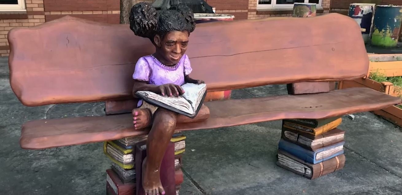 Wooden sculpture, “Girl reading on a bench” at M. Agnes Jones Elementary School in Atlanta, Ga.