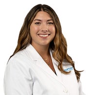 Brunette female in white coat, she is a nurse practitioner