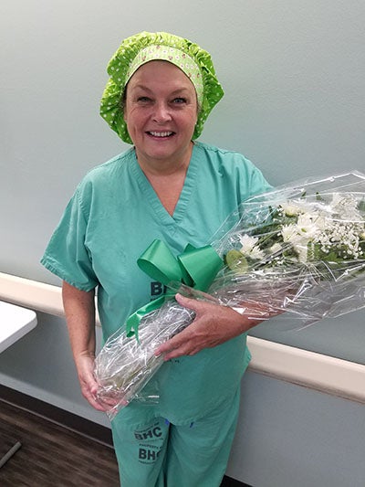 Jayne Voyles in scrubs with flowers