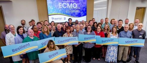 photo of ECMO survivor celebration attendees holding inspirational signs