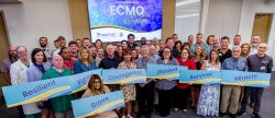 photo of ECMO survivor celebration attendees holding inspirational signs