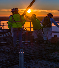 Construction workers at sunset