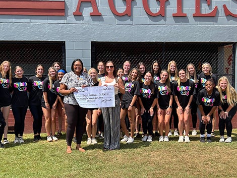 Tate High School Mammogram Fund Donation. Photo of group of girls holding big check. Baptist Health Care Foundation