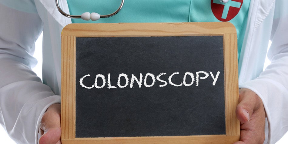 Medical professional holding up a colonoscopy sign
