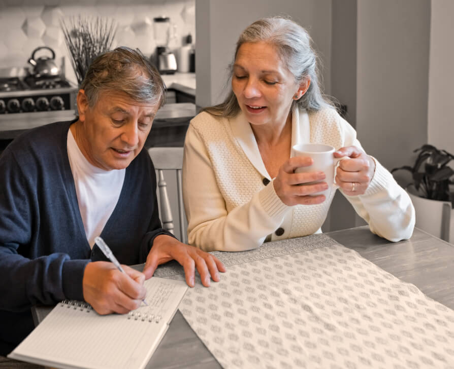 Woman discussing with man writing paper