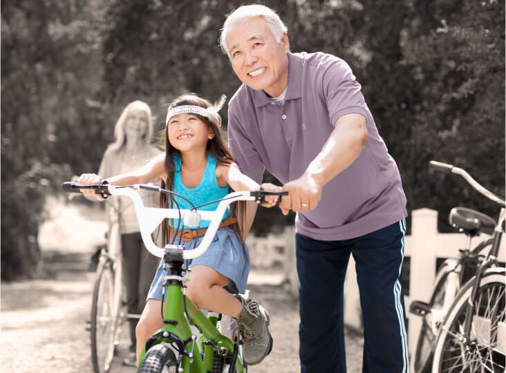 Man pushing girl on bike