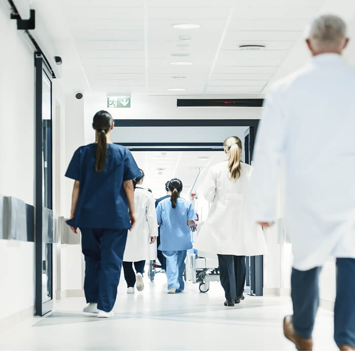 Multiple healthcare professionals walking through hospital