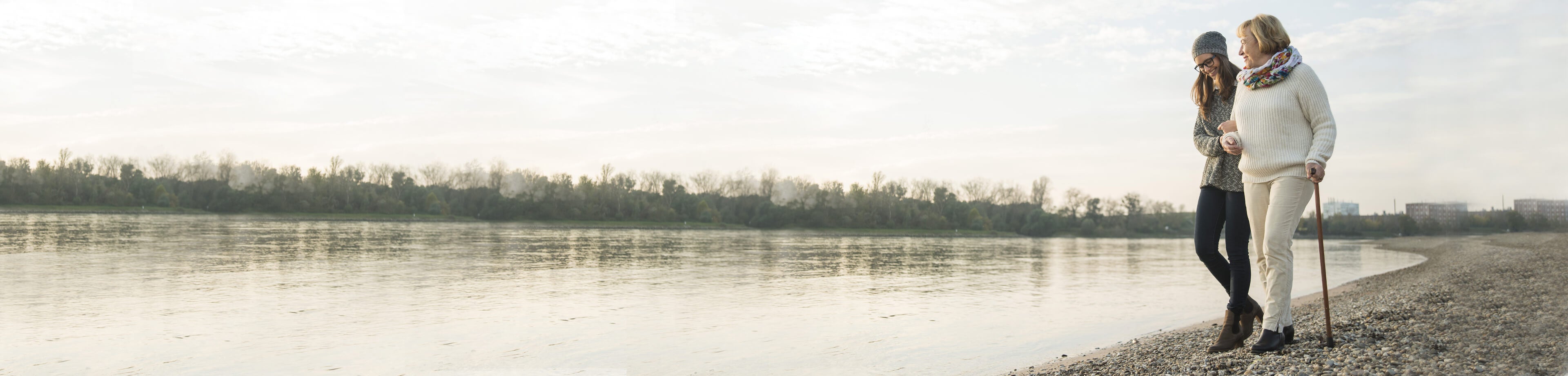 Mother and daughter walking along beach