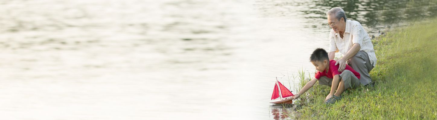 Grandpa and grandson having fun by the river