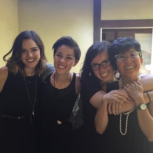 Trish Grannis and her 3 daughters are standing close together smiling for a photo. From left to right it is Emi, Kina, Misa and Trish.
