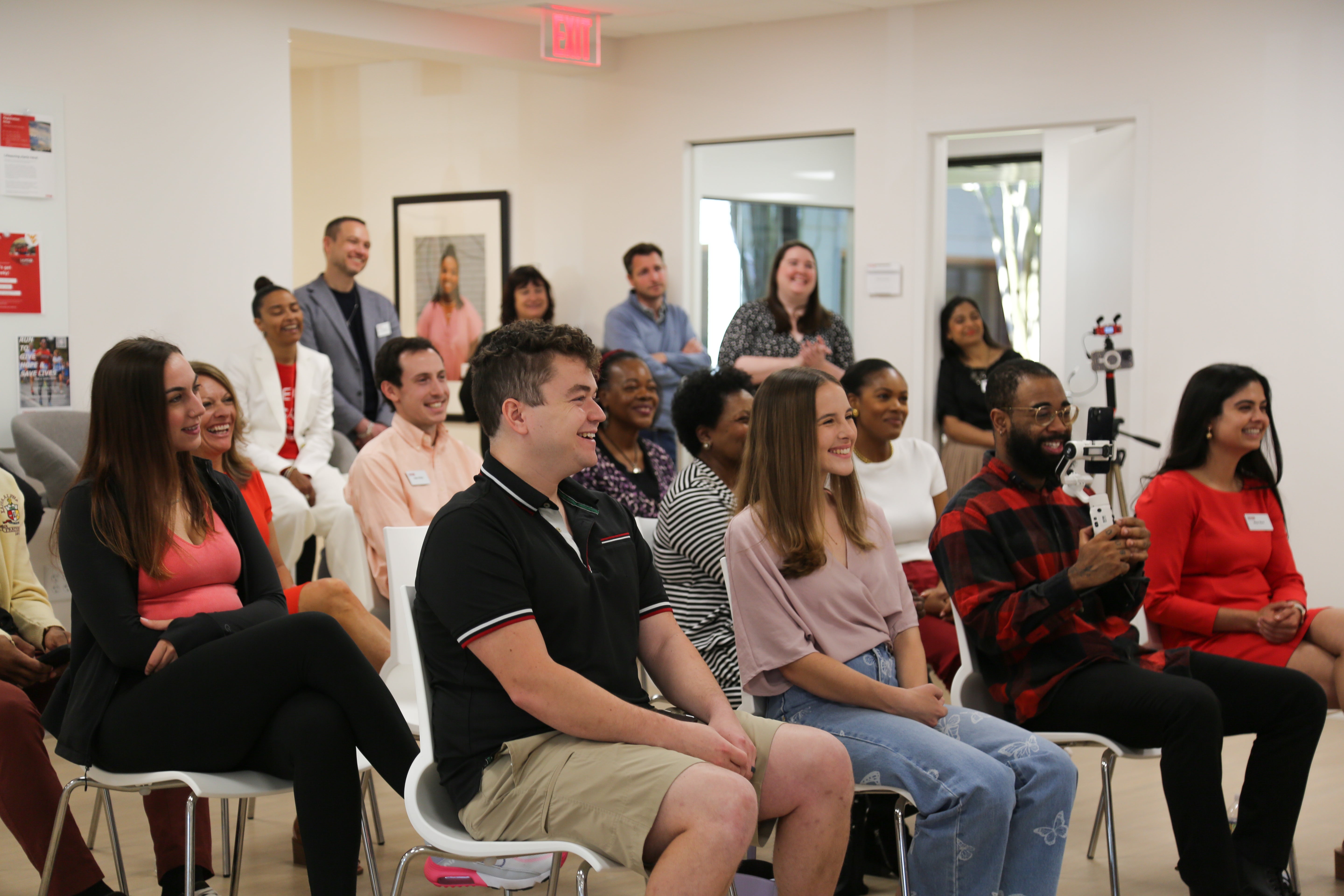 Attendees at the Charlotte Media event held by DKMS react to the speaker. 