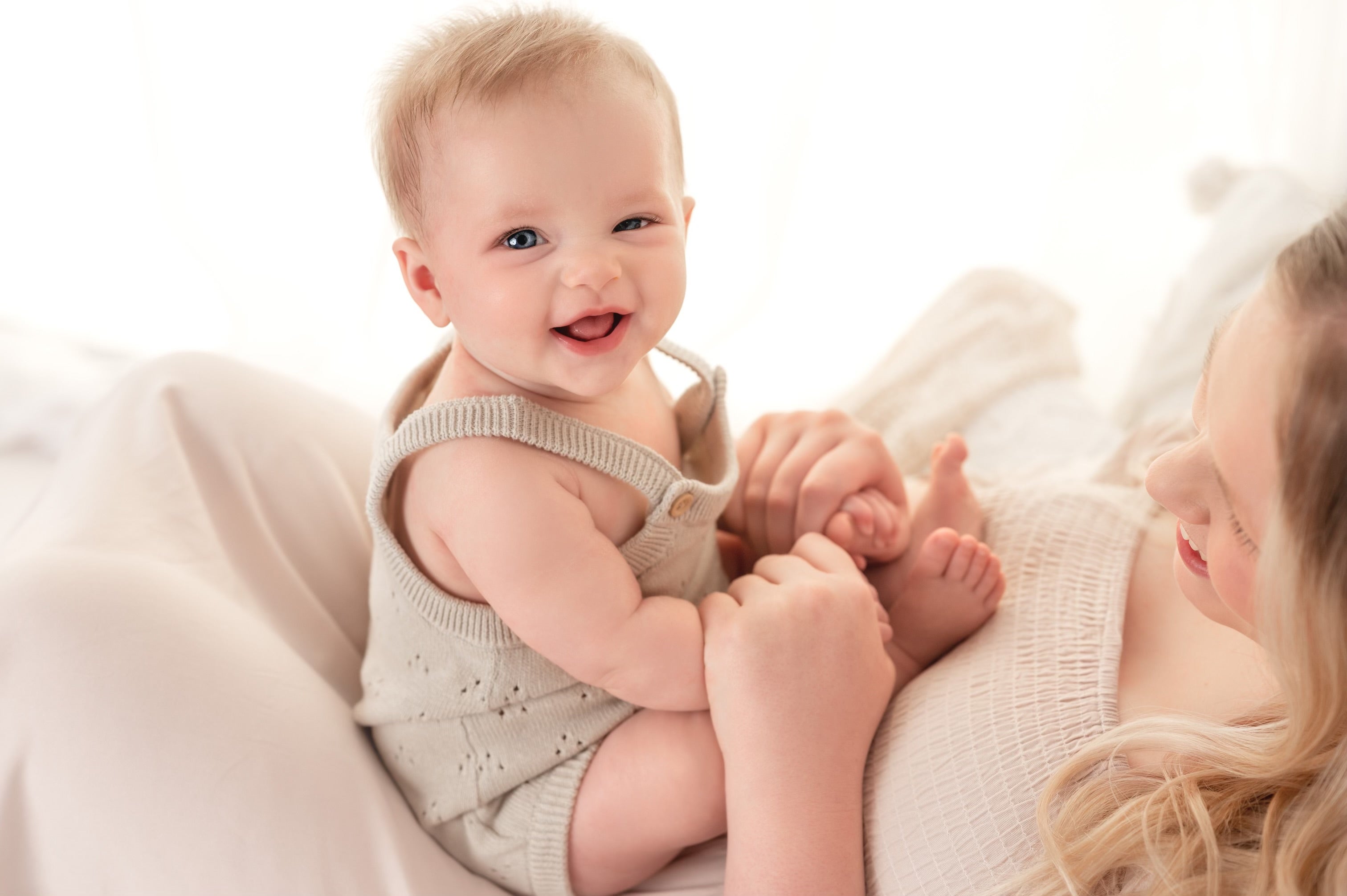 DKMS patient, Clementine, sitting on her mom's lap and smiling.