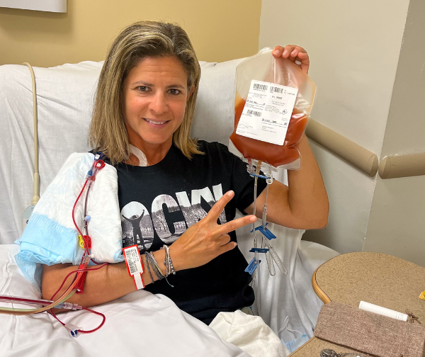 DKMS Donor Alyson holding her blood stem cell donation in a Rocky shirt