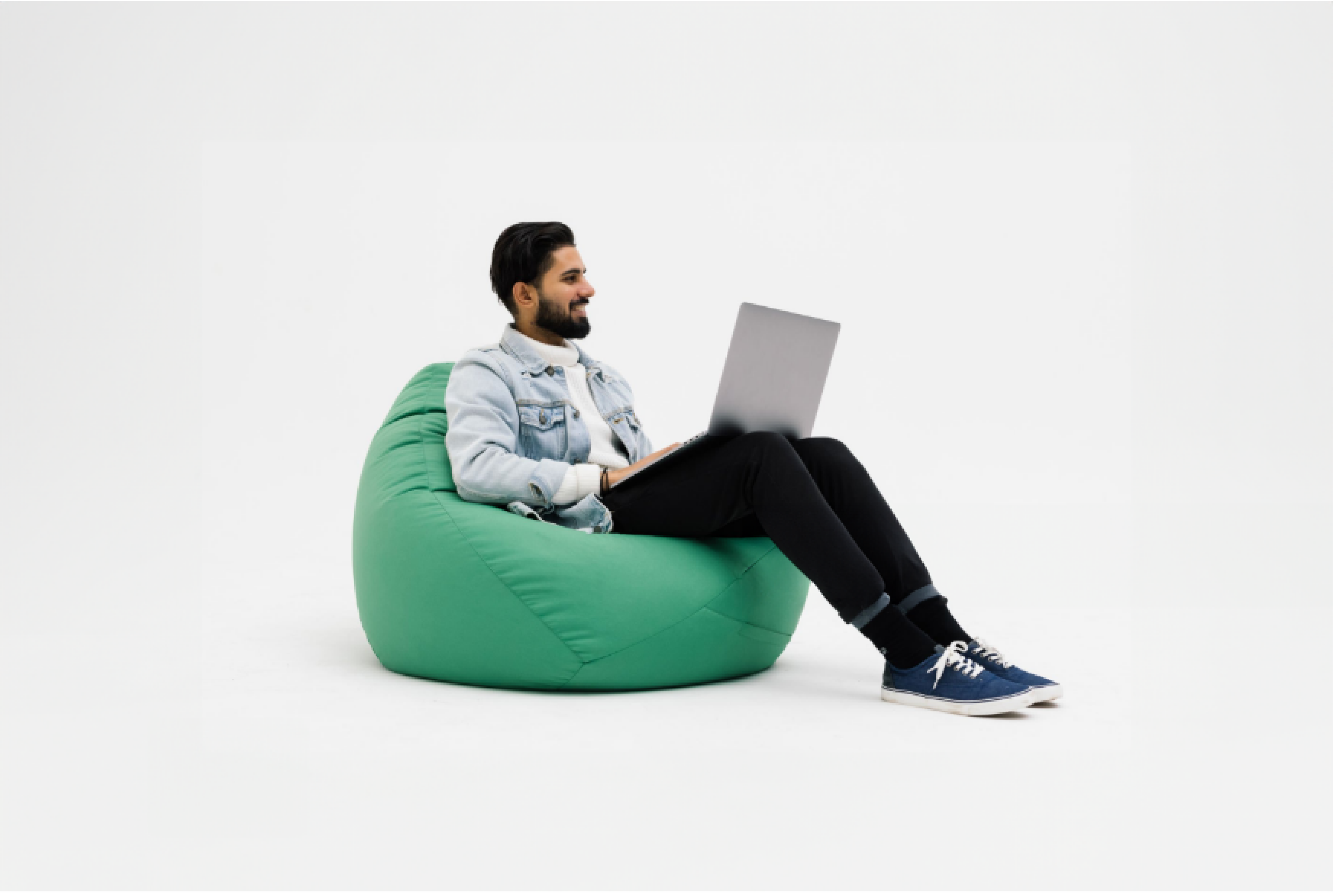 person sitting on beanbag couch using a laptop