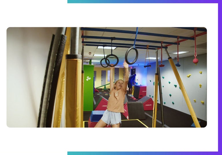 Texas sports academy. A kid swings on an obstacle course.