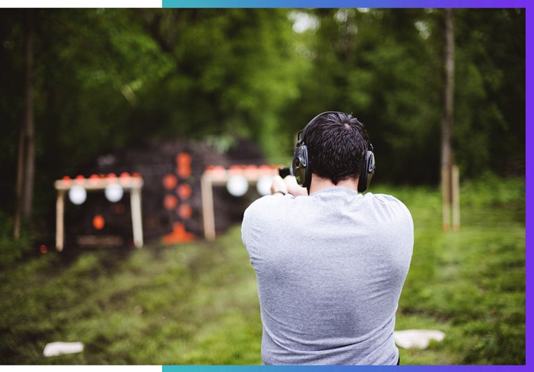 A man shooting and aiming at a shooting range. 