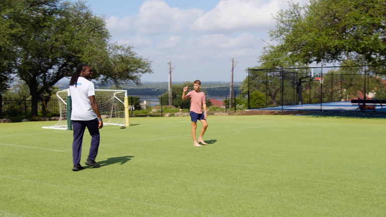 Greg playing soccer outside with students. 