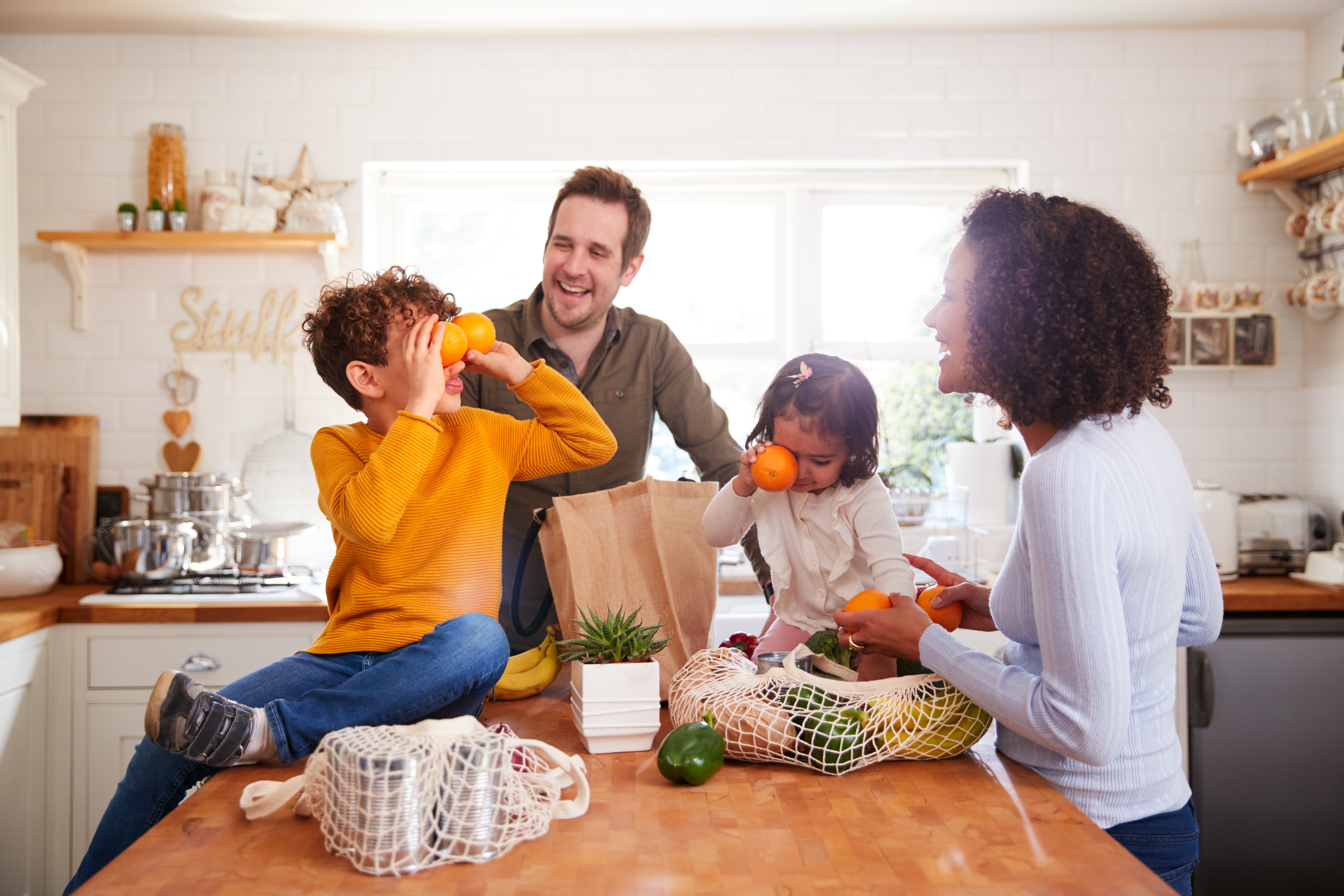 Family in kitchen unpacking groceries