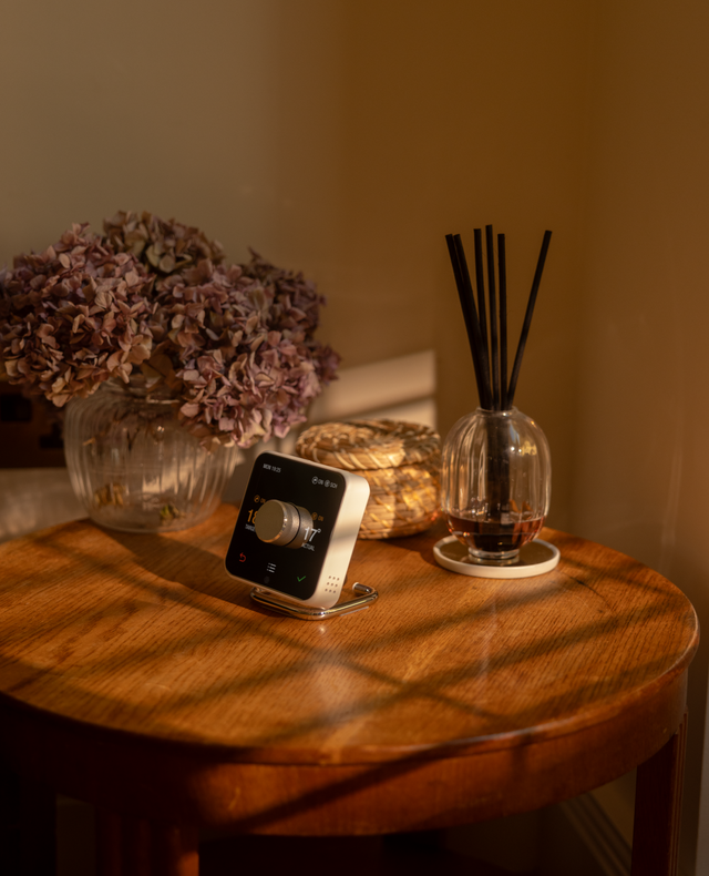 hive thermostat on table with flowers and diffuser