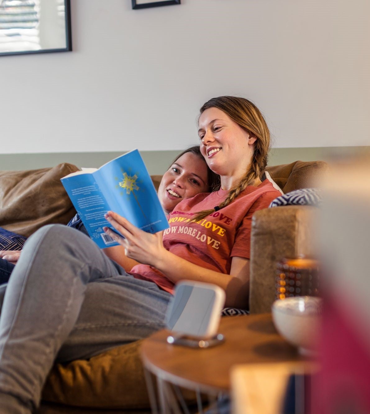 Woman reading book on couch with child