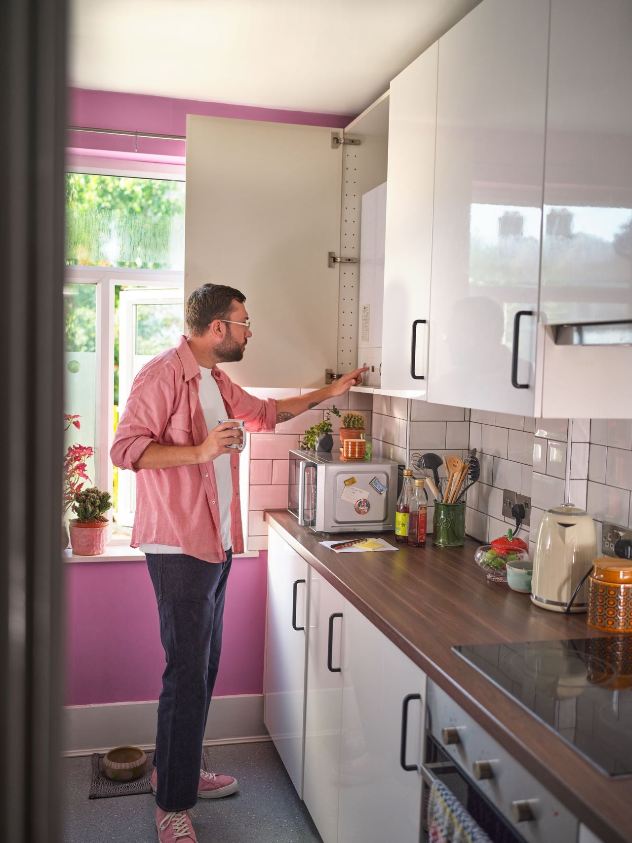 Man in kitchen checking boiler