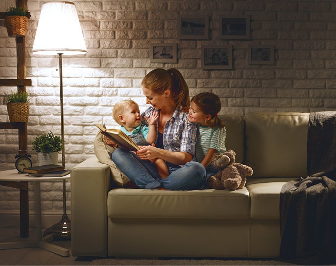 Mother reading story to children on couch