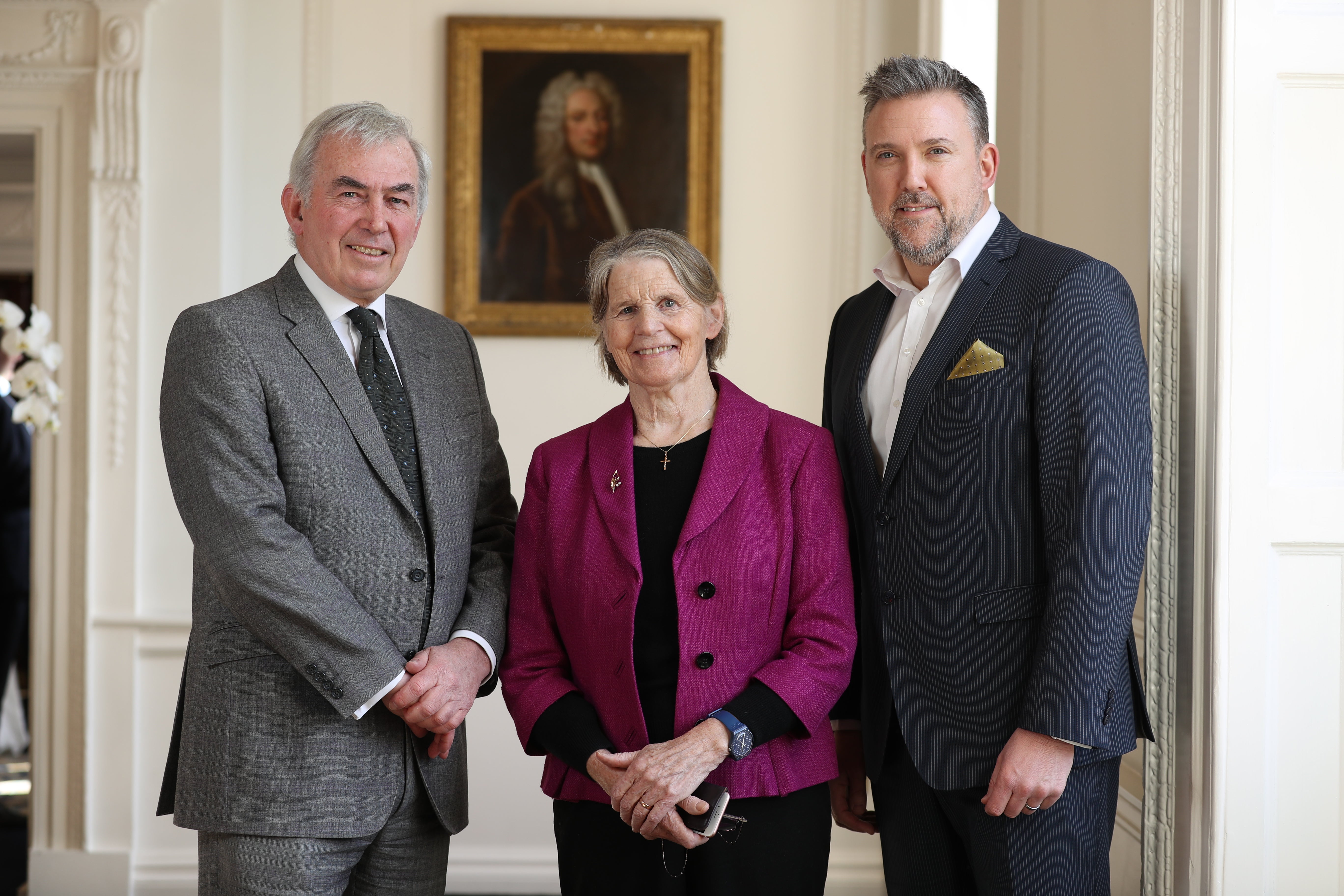 3 people standing in front of a painting