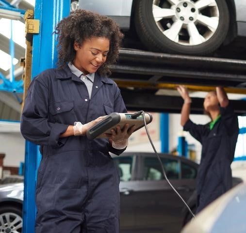 female garage mechanic conducting diagnostic check