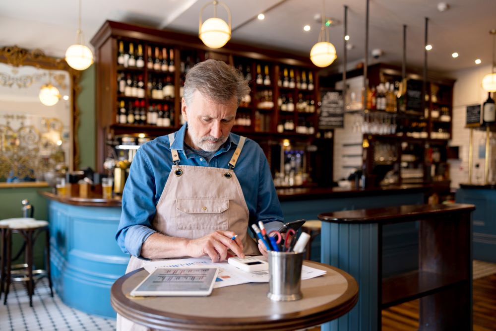 Business owner at pub using calculator