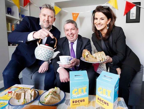 2 men and 1 woman having tea and sandwiches to raise money for Focus Ireland