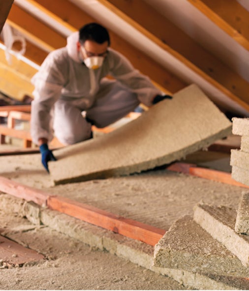 Worker laying down attic insulation