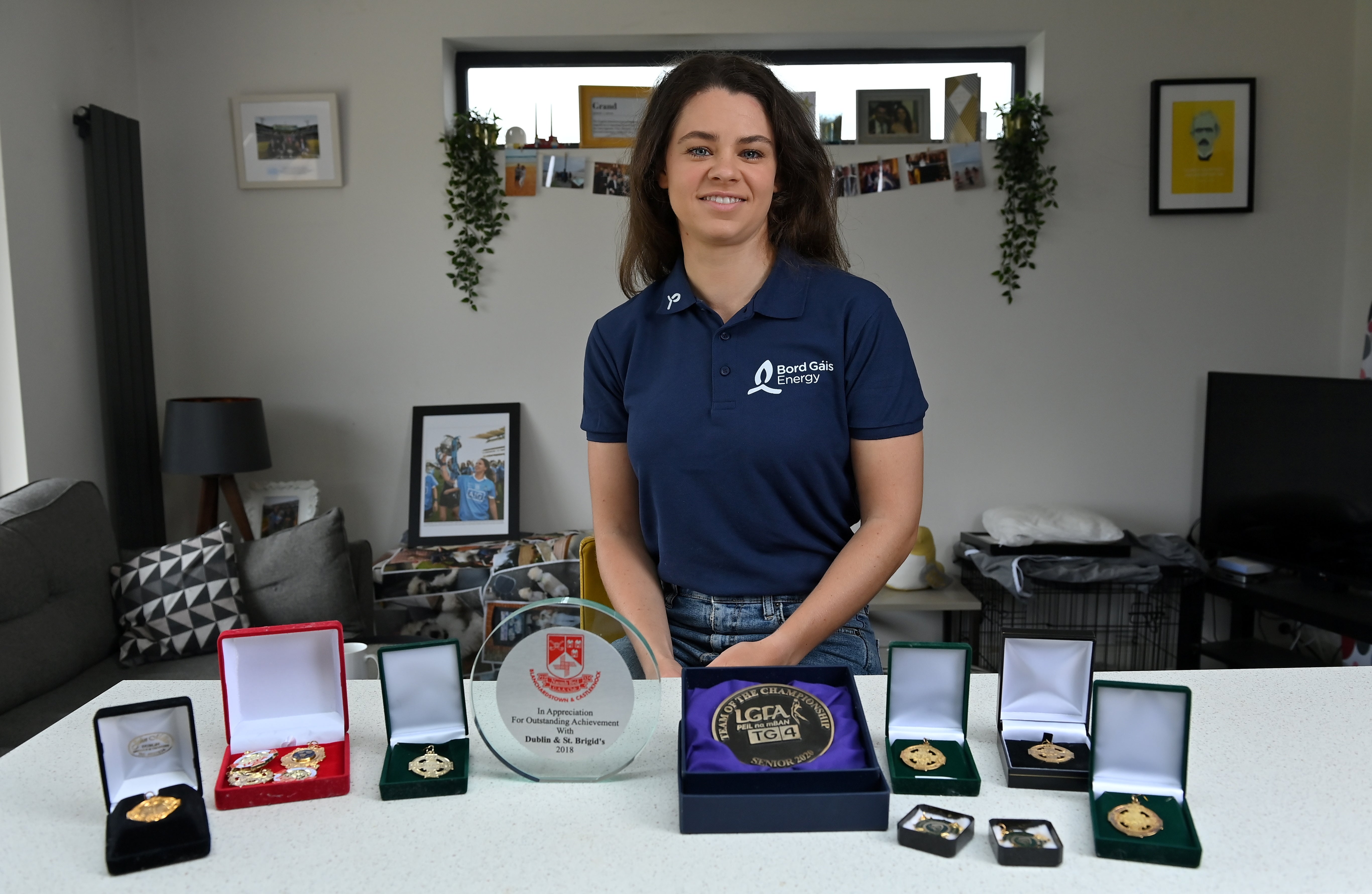 Woman standing with GAA trophy's