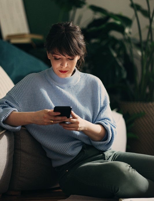 Woman on sofa checking phone