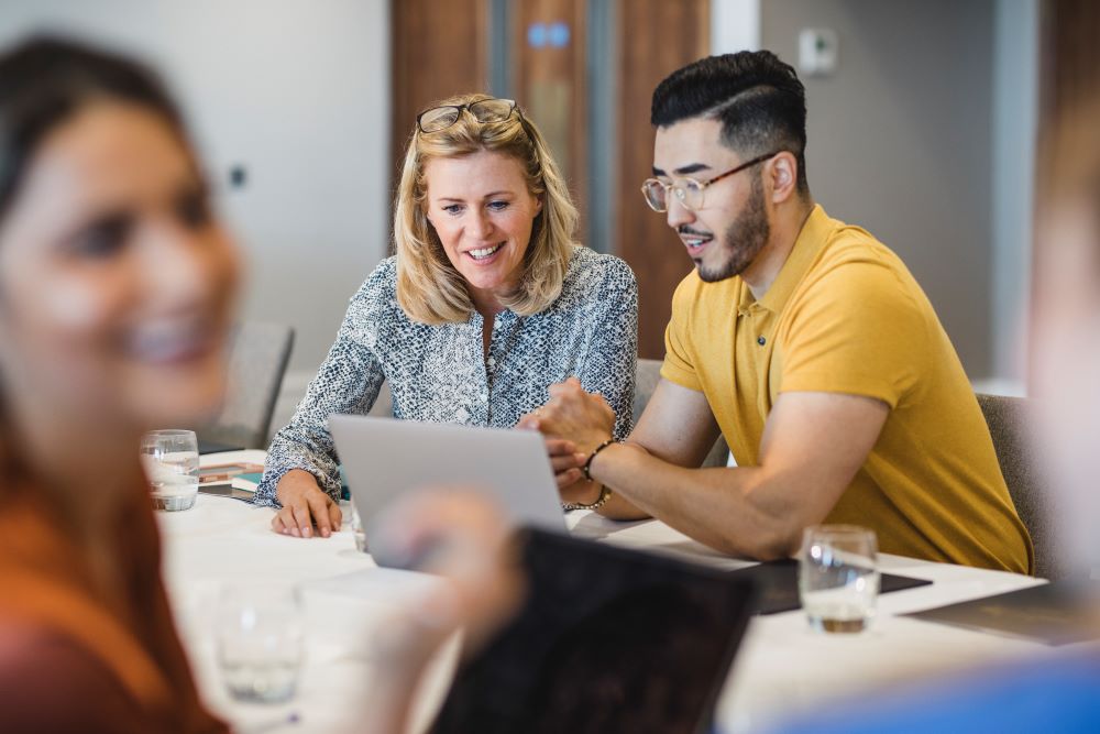 Man and woman working on laptop in office