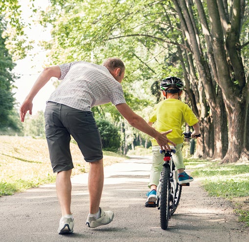 Dad helping son ride bike