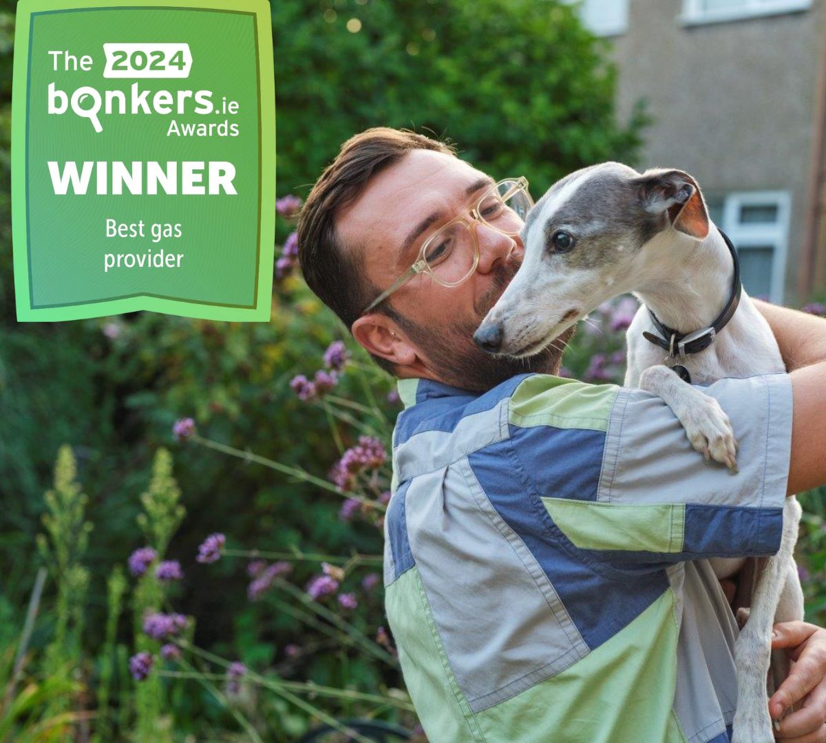 Young man holding greyhound in his arms