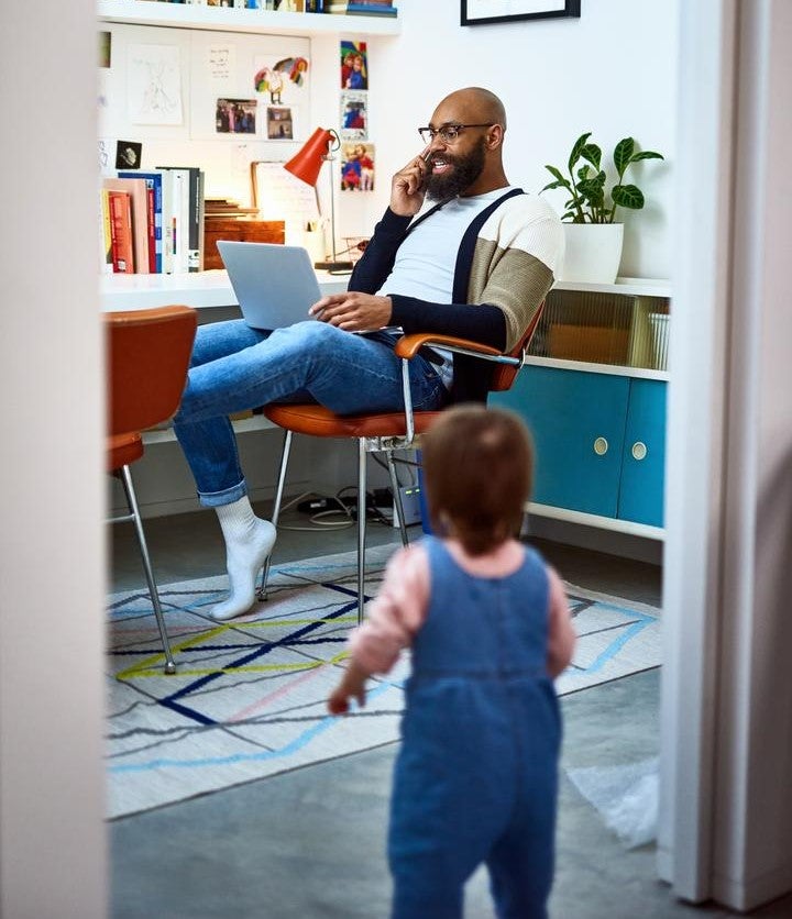 Man working in home office with child in doorway