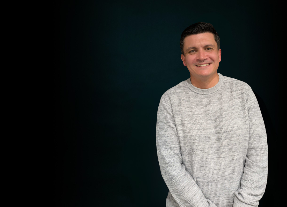 Picture of Jono standing in front of a black screen